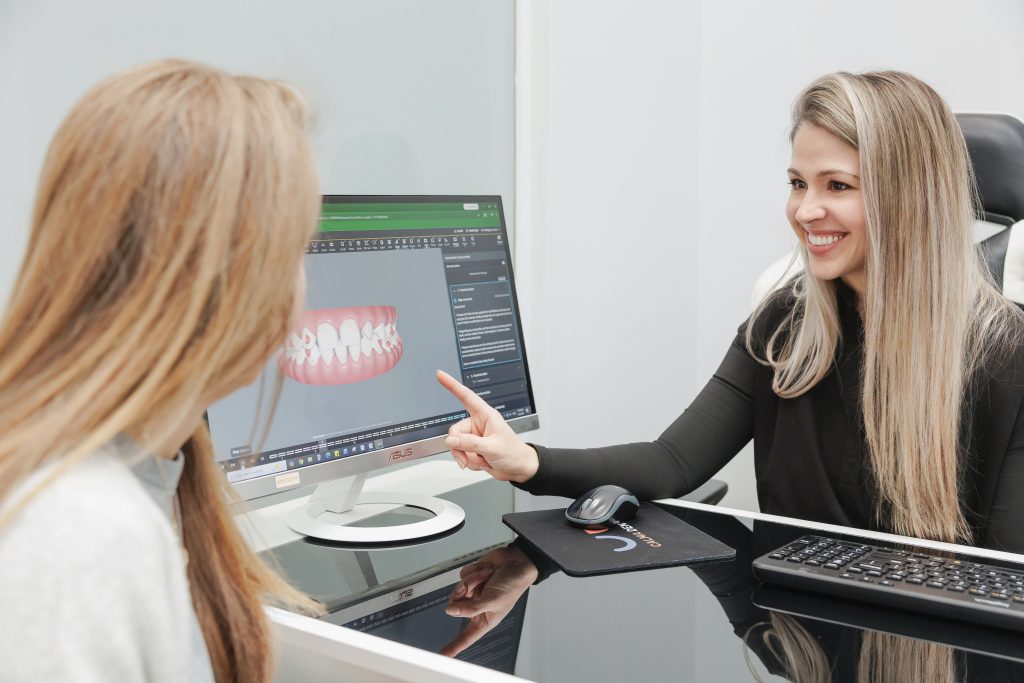 Calma Dental team member reviewing a 3D digital scan of teeth with a patient during a consultation